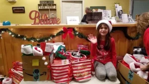 Girl in Santa hat waving